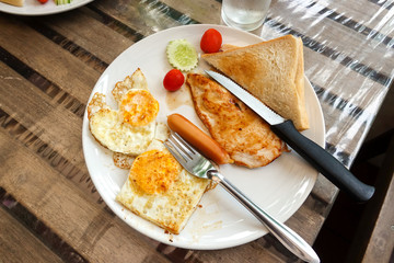 Chicken Steak,  toast and fried eggs in a white plate on a wooden table, Breakfast