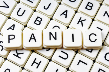 Panic text word crossword. Alphabet letter blocks game texture background. White alphabetical cubes blocks letters on crossword letters educational toy background. Panic.
