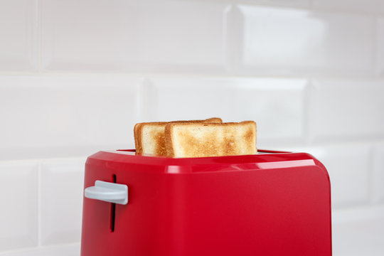 Red toaster with bread slices on white background