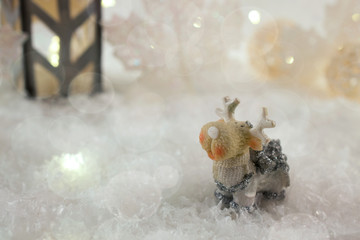 New Year card with toy deer in a fairy forest  on winter background with snow and lights. Template, greeting card