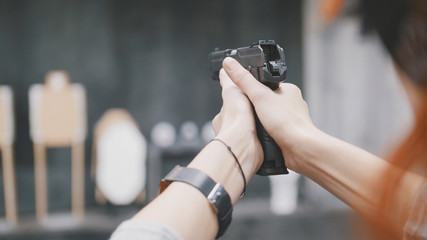 Woman shooting with a gun in shooting gallery