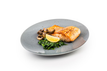 Salmon Roast Fillet. Portion of roast salmon fillet with spinach mushrooms isolated on white background