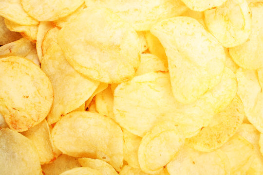 Chips pattern. Yellow salted potato chips as background. Chips texture studio photo Food photo.