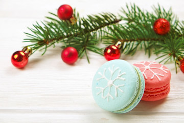 Traditional christmas themed french macaroons sweets in the form of snowman, snowflake, christmas tree and santa's belly with candy cane on the white wooden table.  Close up.