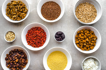 Vegetarian breakfast with healthy food selection, nuts, seeds, goji berries and other superfoods on table, flat lay, overhead