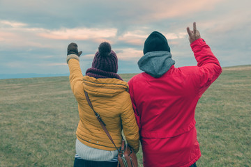 Couple in nature saluting the scenery with hands in the air.