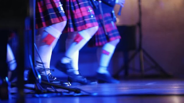 Traditional scottish band musicians singing with bagpipes on the stage