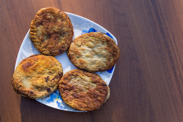 Fried cutlets in a plate on wooden table. Top view
