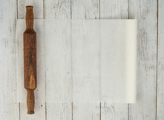 Old wooden rolling pin on rustic wooden background. Top view with copy space