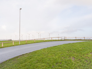 Schmale Straße entlang einer Windfarm Hintergrund