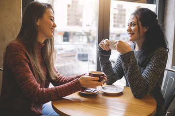 The girls drink coffee in the cafe.