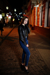 Night portrait of girl model wear on glasses, jeans and leather jacket, with backpack , against city streets.