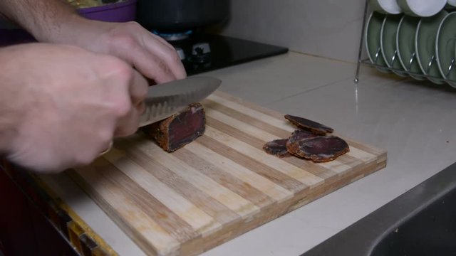 male hands slicing the draid meat. basturma traditional turkish armenian dish
