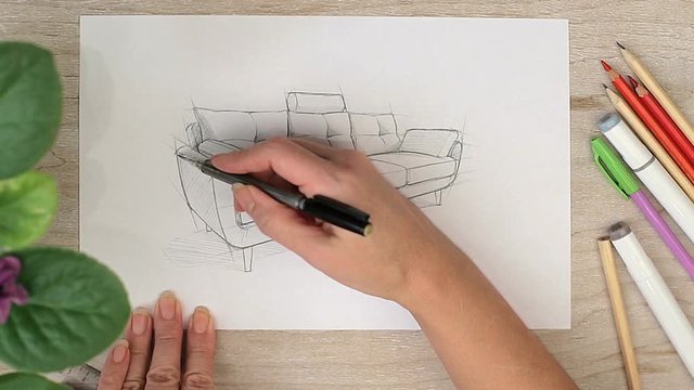 Woman arms drawing sketch of sofa