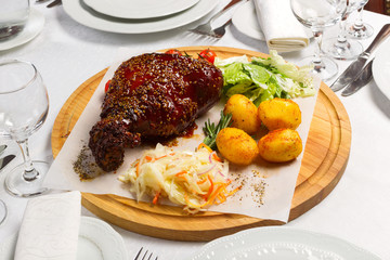 Meat with garnish of vegetables on a wooden board