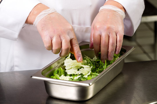 Cooking food. The hands of the chef make a salad