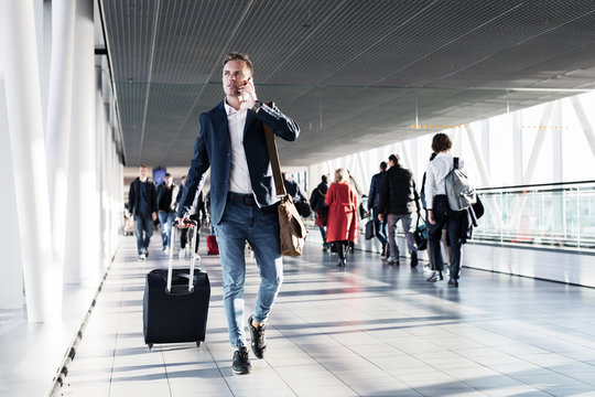 Busy man speaking on phone and walking in airport