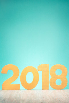2018 date on wooden table front gradient mint green wall. Happy New Year greeting card or calendar background. Retro old style filtered photo
