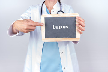 Arzt mit Schild zu Lupus Erkrankung