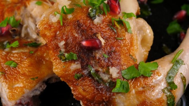 Chicken roasted, close-up view, with garnet seeds and parsley, Georgian or Caucasus style cuisine, loop, 4K, ProRes codec, 422 HQ