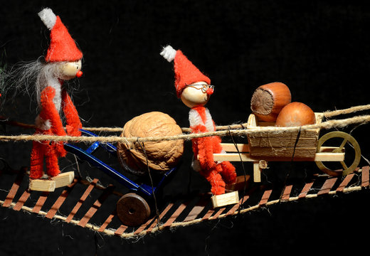 Pixie gang vrosses a wobbly bridge wih look carried odn dollies and wheelbar.