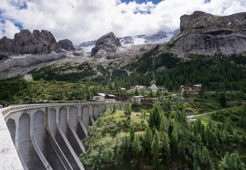 the dam at Lago di Fedaia and the mountains of the Italian Dolomites in fall