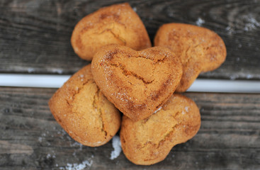 Homemade cookies with sugar and cinnamon in the form of hearts on a wooden background