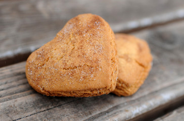 Homemade cookies with sugar and cinnamon in the form of hearts on a wooden background