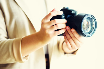 Girl hands holding photo camera, white background, copy space. Travel and shoot concept