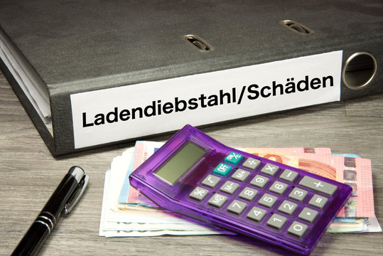 Euro Geldscheine, Taschenrechner und ein Ordner mit dem Aufdruck Ladendiebstahl Sch&auml;den