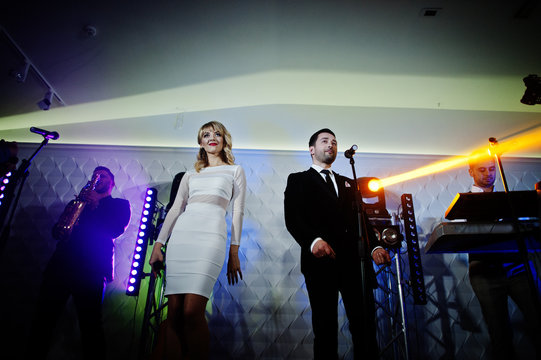 Musicial music live band performing on a stage with different lights.