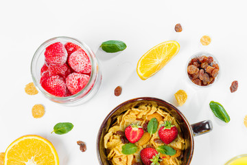 Cereal, morning breakfast, corn flakes, raisins, almonds, mint leaves, orange juice, strawberry, top view, white background, flat lay. The concept of healthy, proper nutrition, ditox.