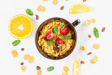 Cereal, morning breakfast, corn flakes, raisins, almonds, mint leaves, orange juice, strawberry, top view, white background, flat lay. The concept of healthy, proper nutrition, ditox.