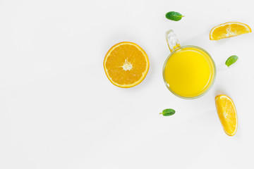 Cut orange, slices, mint leaves, orange juice in a glass top view on a white background, flat lay. The concept of healthy, proper nutrition, ditox.