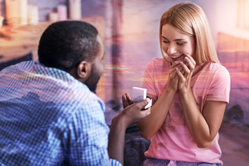 Romantic moment. Happy beautiful young girl looking at her boyfriend and smiling while getting a marriage proposal