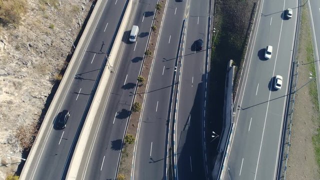 Aerovideo: unmanned aircraft flying over free interstate expressway with machines at autumn day. The modern architecture of curvy autoban, many different winding turn. Casual lifestyle in megapolis