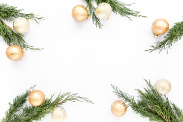 Christmas or new year frame composition. Christmas balls in gold colors on fir branches on white background with empty copy space for text. Holiday and celebration concept. Top view. Flat lay