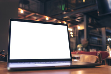 Mockup image of laptop with blank white screen on wooden table in modern loft cafe