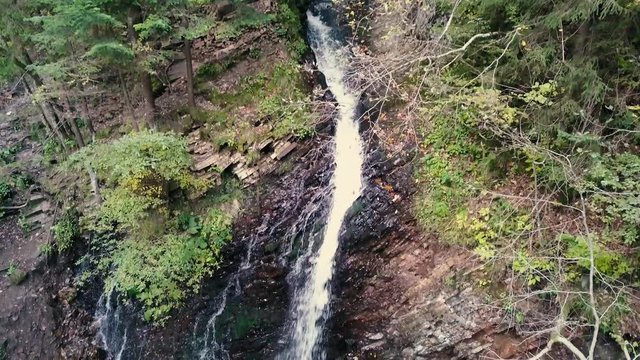 Beautiful autumn waterfall Zhenetskyi Huk in carpathian mountains, Ukraine. Aerial shoot from drone