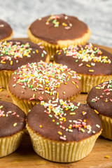 Vanilla cupcakes with chocolate cream and colorful sprinkles