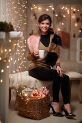 Young woman at fireplace with hot drink