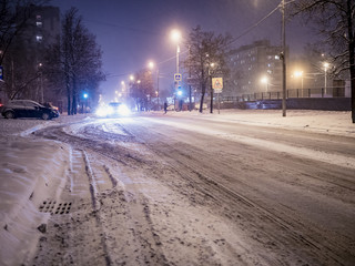 Obraz premium night winter snowy city road with the car passing by