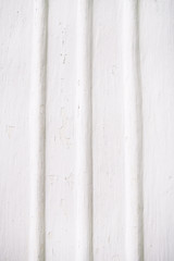 Old rippled white wall with cracked paint.