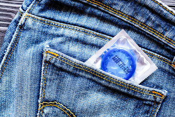 concept male contraception condom in jeans pocket