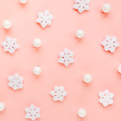 Holiday texture with white christmas snowflakes on pink background. Christmas composition, wallpaper. Flat lay, top view