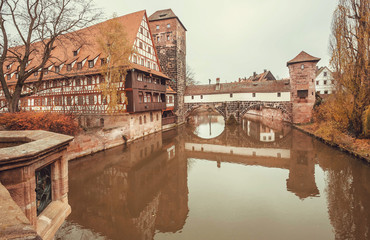 Calm river in historical Bavarian city with bridge and old houses