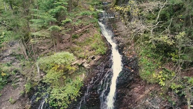 Beautiful autumn waterfall Zhenetskyi Huk in carpathian mountains, Ukraine. Aerial shoot from drone