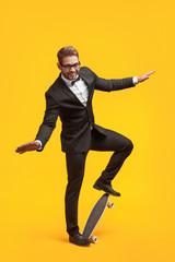 Fototapeta na wymiar Stylish man in suit posing with longboard