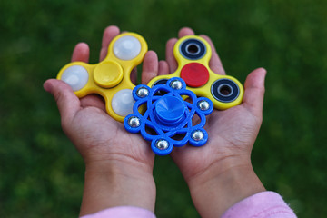 several colored spinners in the hands of a child as a background
