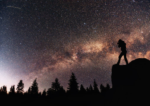 Silhouette Nature photographer with digital camera, background of the Milky Way galaxy on a bright star dark sky tone